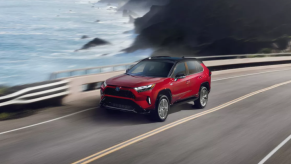 Supersonic Red 2022 Toyota RAV4 Prime driving on a coastal road