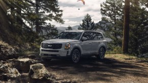 A slate gray 2022 Kia Telluride parked in the woods.