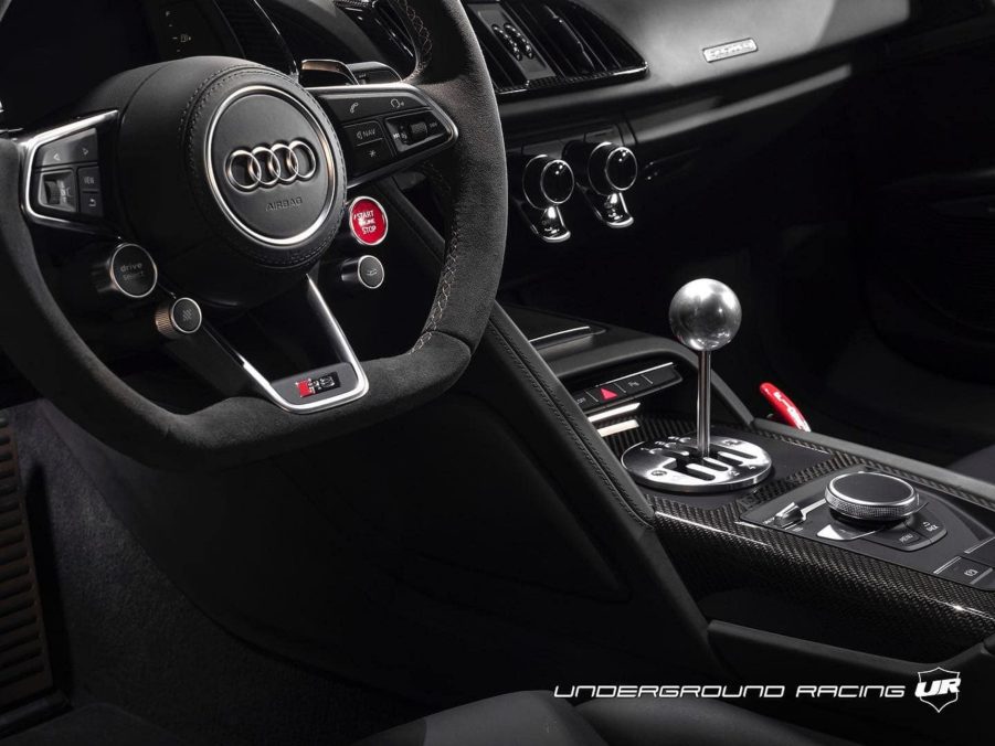 The steering wheel and carbon-fiber center console of a 2020 Audi R8 Decennium with a gated manual shifter modified by Underground Racing