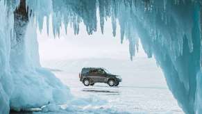 View of an SUV through an ice cave, highlighting article about how to start a car in cold weather