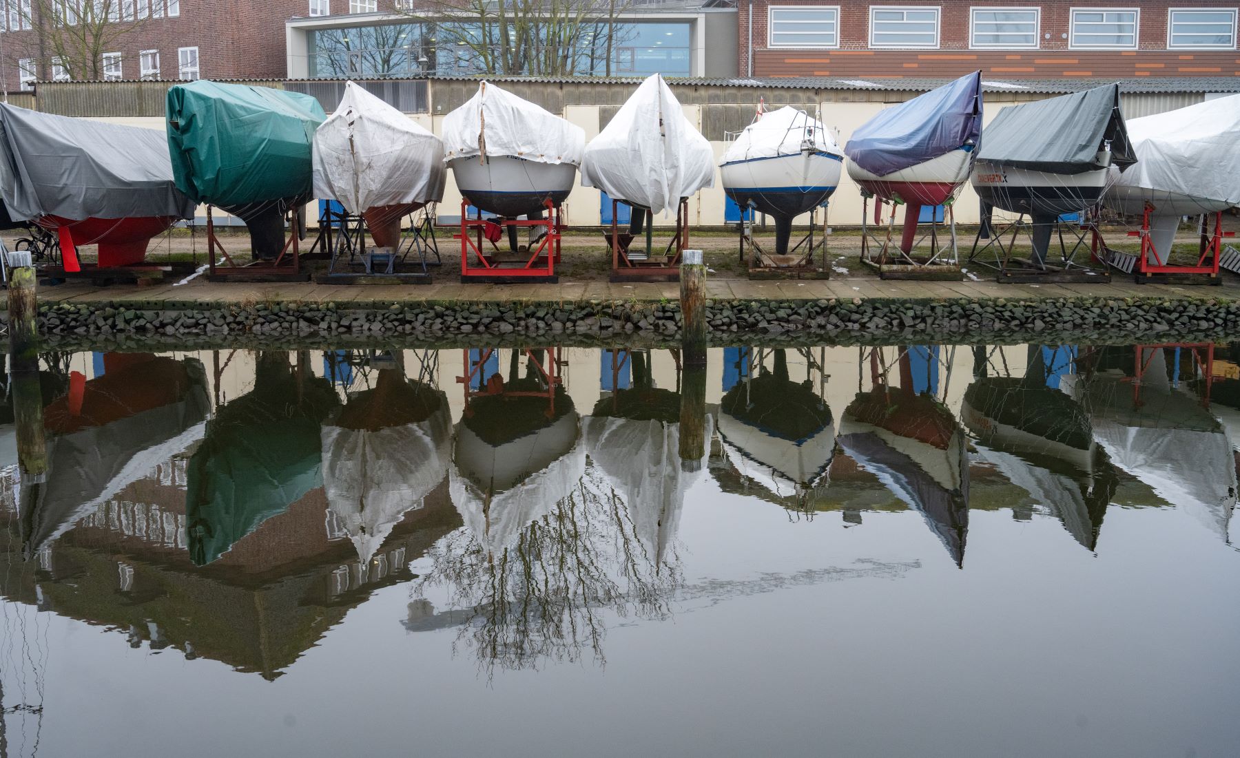 Boats covered and docked on land during winter in Mecklenburg-Wester Pomerania, Stralsund by the Baltic Sea