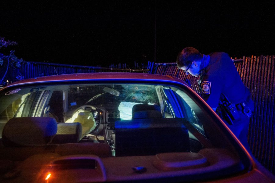 cop looking inside of a crashed car