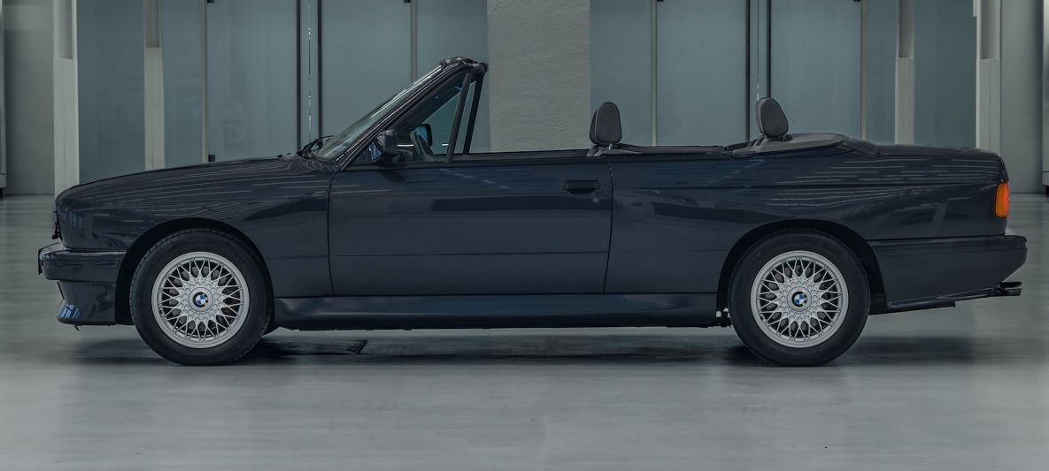 A profile view of a BMW E30 M3 convertible in blue.