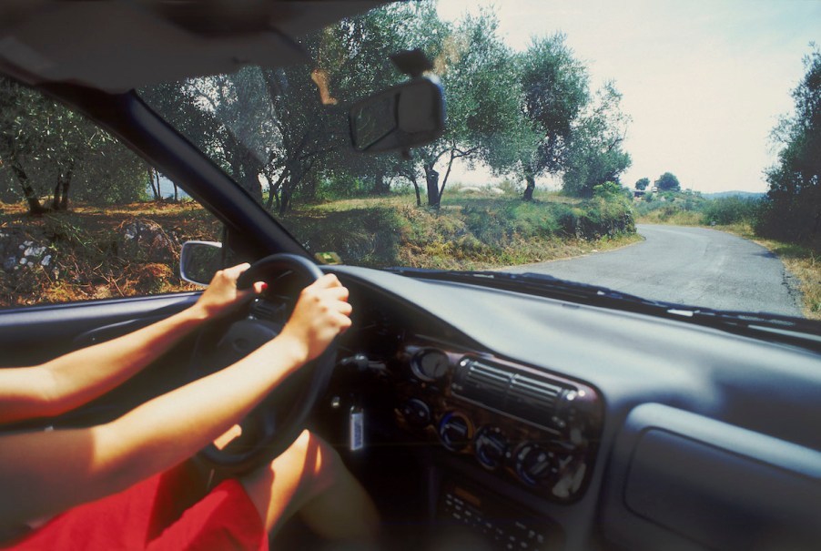 A woman's hands on a steering wheel while driving in Ibiza, Spain, in 2004