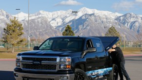 A man lifts a tonneau cover on a Chevy pickup truck in 2005 in Orem, Utah