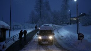 A van drives through winter weather in a snow storm