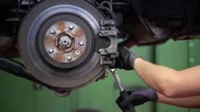 car mechanic wrenching on brakes