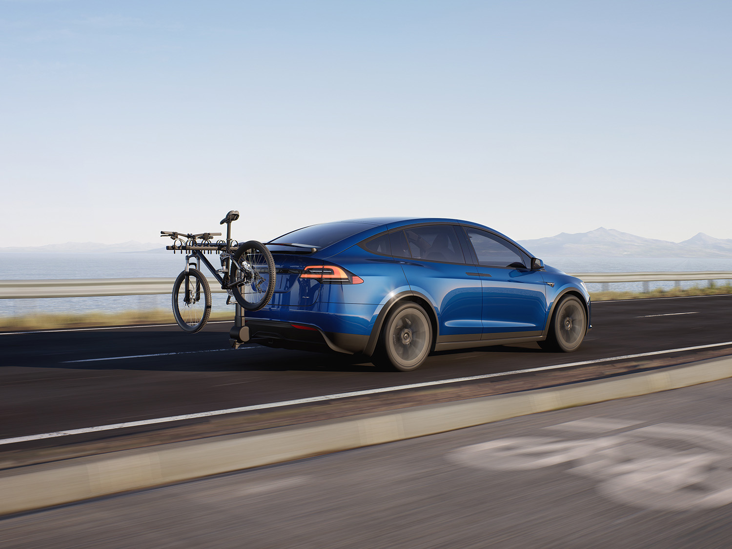 Blue Tesla Model X SUV with bike rack rear passenger side