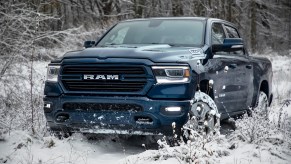 Blue Ram 1500 truck parked in the middle of snowy woods.