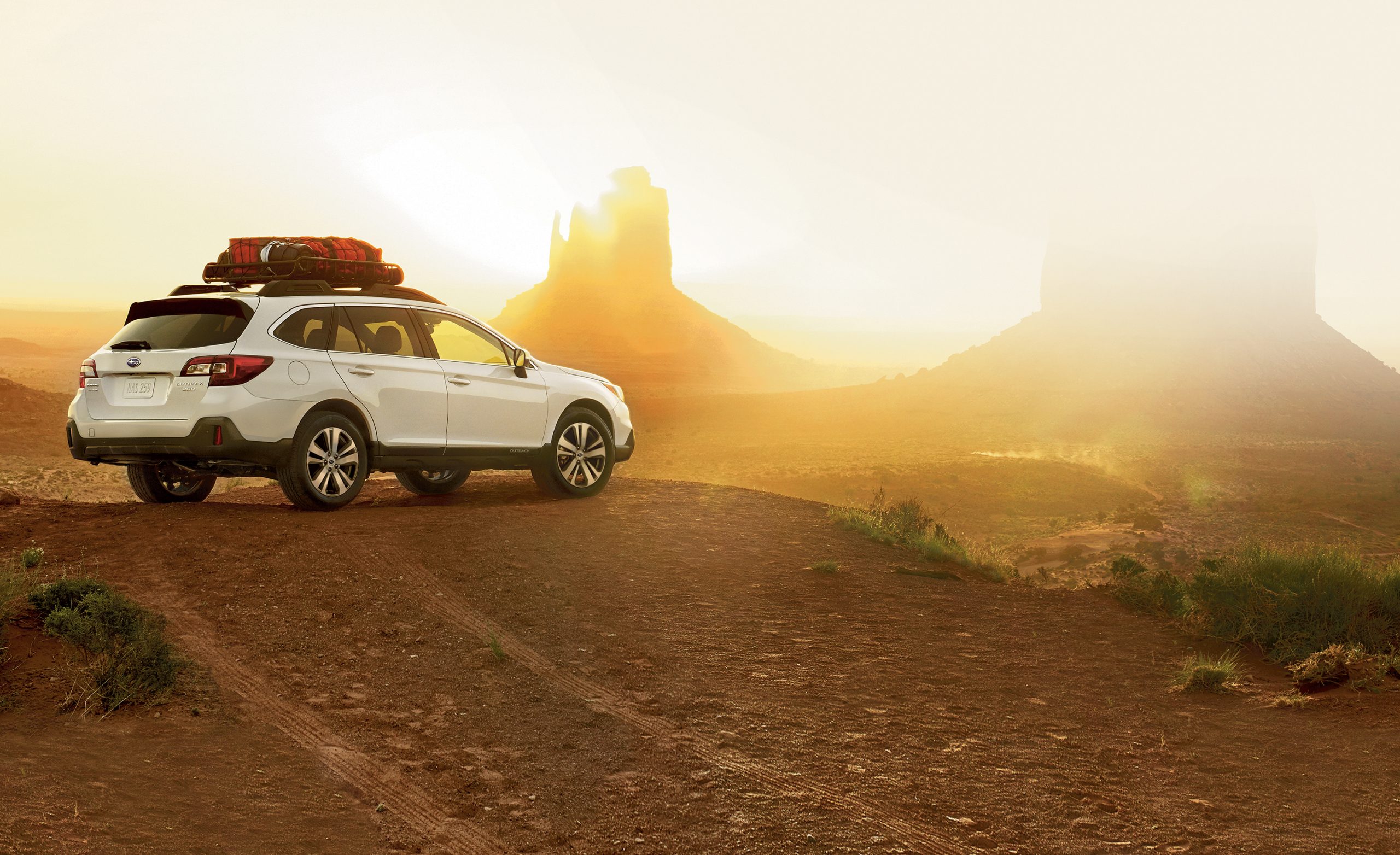 A white Outback with a roof basket in the desert