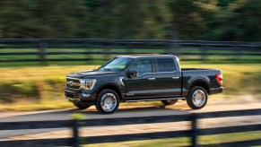 2021 Ford F-150 PowerBoost driving down a dirt road.