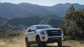 A white 2022 GMC Yukon AT4 in an outdoor mountainous environment.