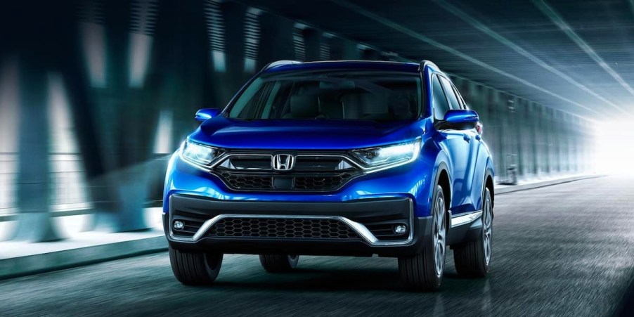 A blue 2022 Honda CR-V small SUV is driving on the road.