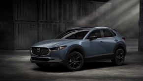 A slate-blue 2022 Mazda CX-30 2.5 S Carbon Edition subcompact SUV in a warehouse