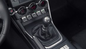 The manual transmission shifter in the black center console of a 2022 Toyota GR86 Premium