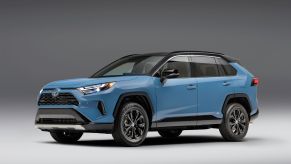 A light blue Toyota RAV4 in a black and white room.