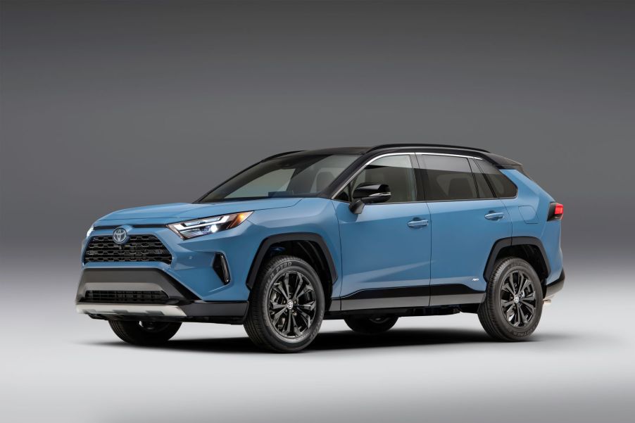 A light blue Toyota RAV4 in a black and white room.