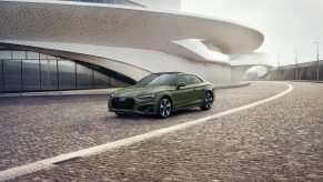 A 3/4 front view of a 2020 Audi A5 Coupe in green, parked in front of a white building.