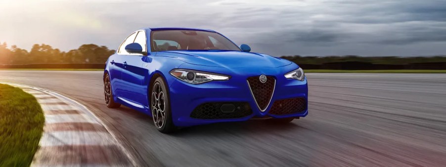 A 3/4 front view of a blue 2022 Alfa Romeo Giulia sedan driving on a race track