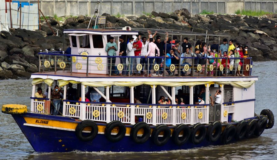 A large boat on the water with people on both levels of the boat.