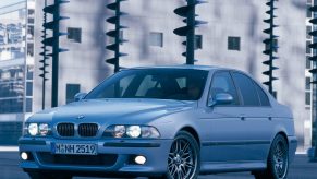 A silver E39 BMW M5 in a city parking lot