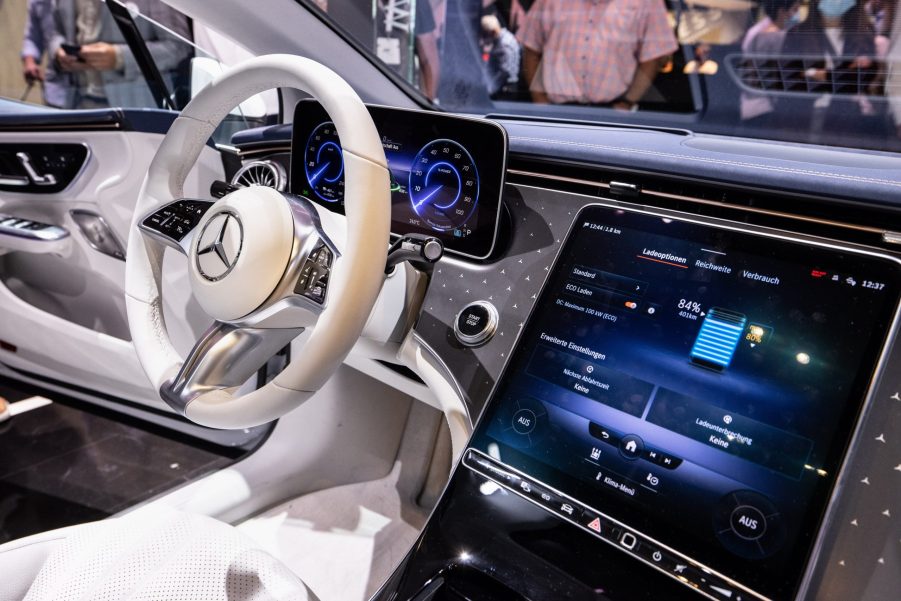 An interior view of a Mercedes-Benz EQS showing the steering wheel, dashboard and infotainment display.