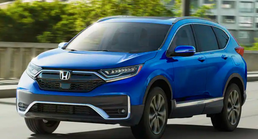 A blue 2022 Honda CR-V is driving on the road.