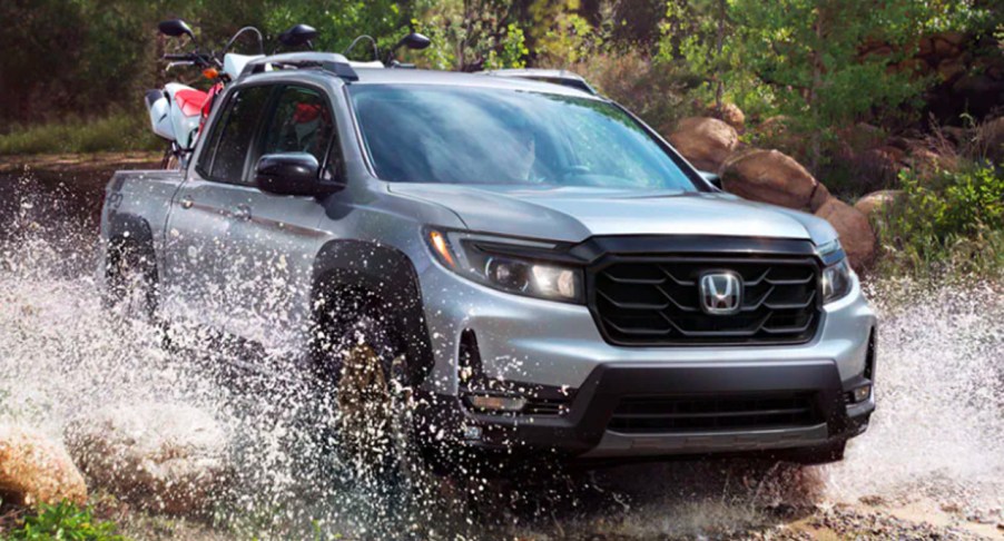 A gray 2022 Honda Ridgeline is driving through water.