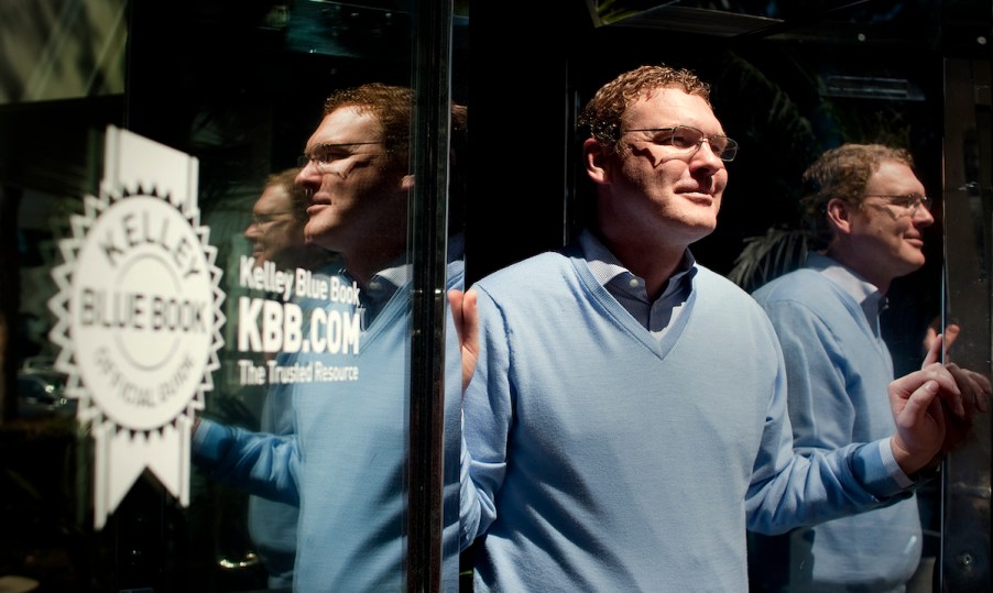 Kelley Blue Book president Jared Rowe stands next to the KBB logo on April 3, 2013, in Irvine, California