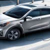 A gray Kia Niro PHEV is charging.