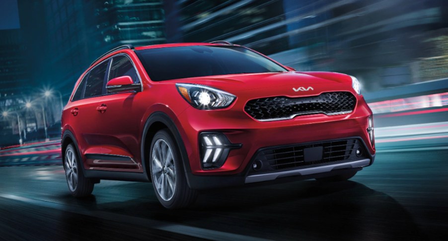 A red Kia Niro Plug-in Hybrid SUV is driving.