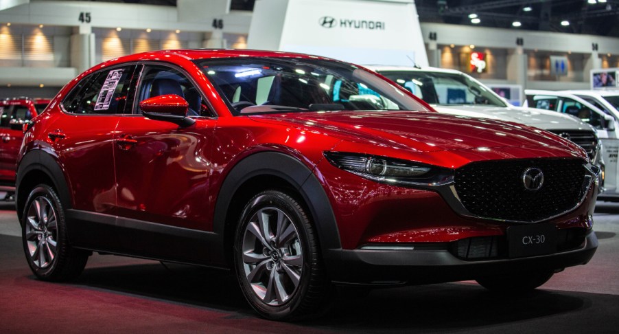 A red Mazda CX-30 is on display.