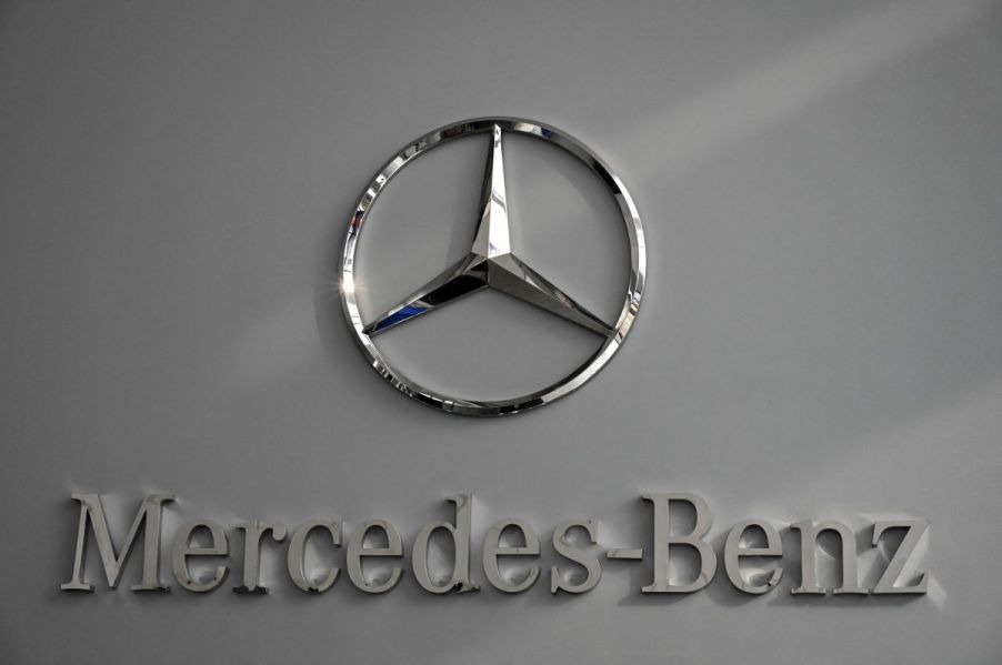 A chrome Mercedes-Benz logo on a gray background.