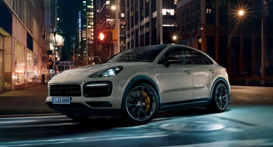 A white 2022 Porsche Cayenne GT Turbo is driving on the road.