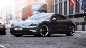 A black Porsche Taycan Turbo S EV shot from the 3/4 angle on a London street