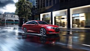 Radiant Red Metallic 2022 Honda Accord driving on a wet street