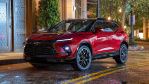 Radiant Red Metallic 2023 Chevy Blazer RS parked next to a sidewalk