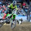 Riders on a dirt bike in safety gear on a track