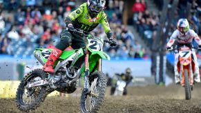 Riders on a dirt bike in safety gear on a track