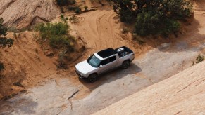 A gray 2022 Rivian R1T is driving off-road.