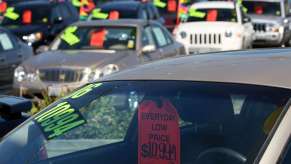 Sales stickers on a cars at dealership, highlighting negotiating tips to save money at a car dealer