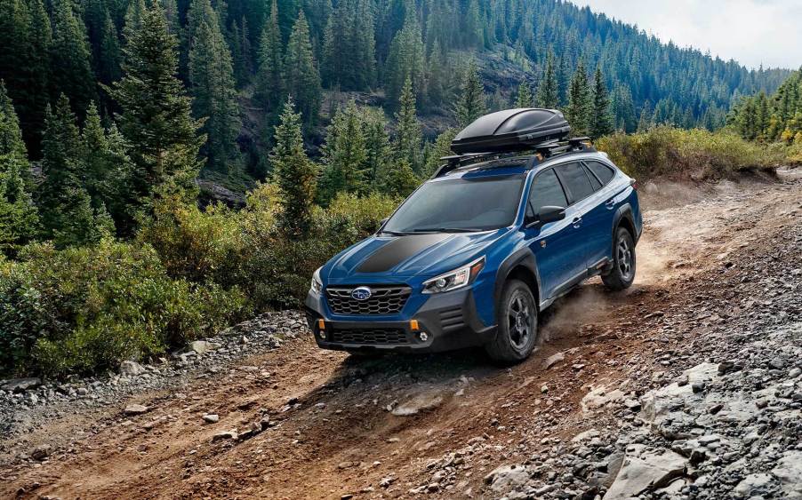 A blue 2022 Subaru Outback in the woods.