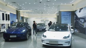 A blue and a white Tesla Model 3 in a Chinese dealer during a recall