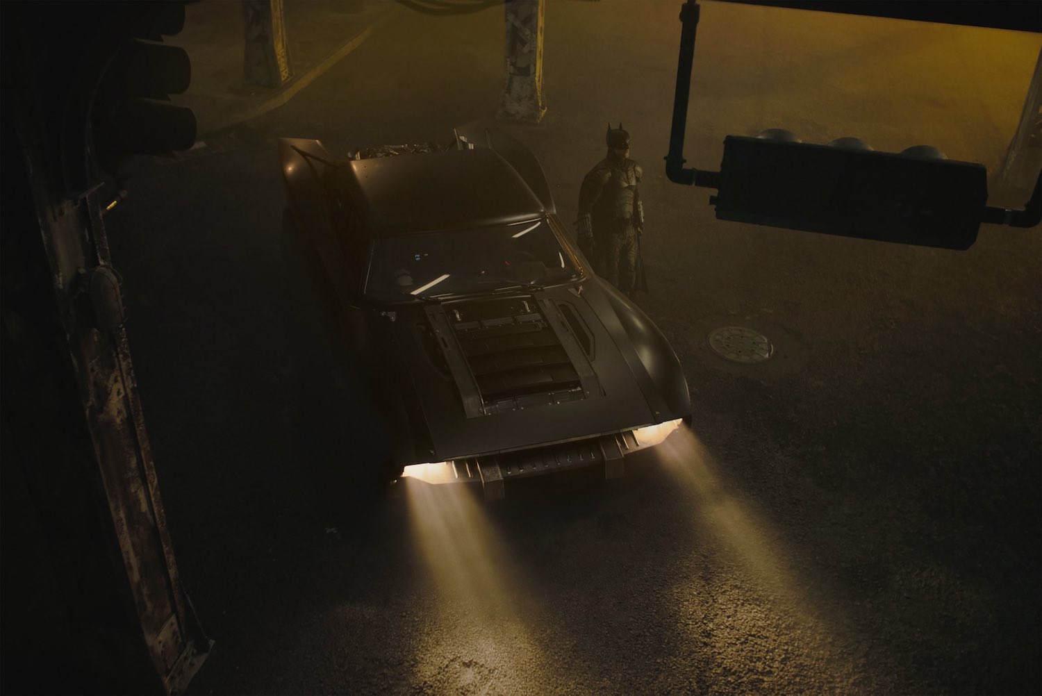 A birds-eye view of batman and the muscle-car based new batmobile in an intersection.