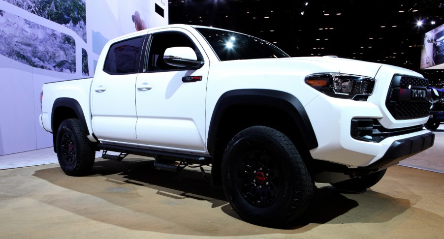 A white Toyota Tacoma midsize pickup truck is on display.