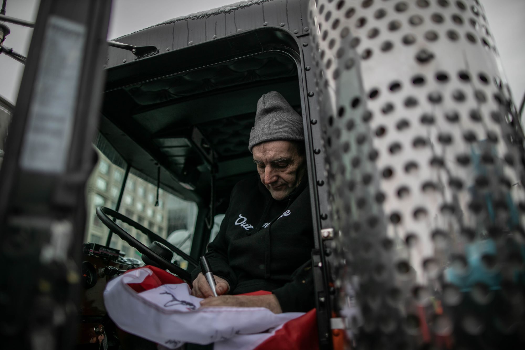 A potentially seasoned truck driver sitting in his truck. 