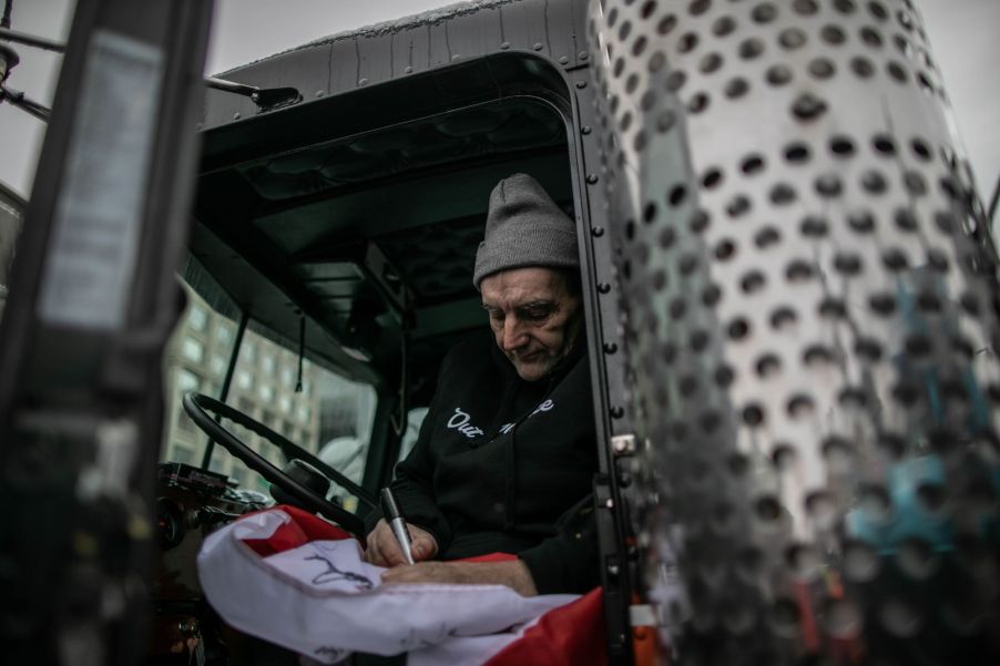 A potentially seasoned truck driver sitting in his truck.