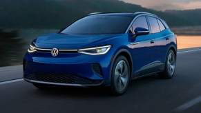 A blue 2022 Volkswagen ID. 4 electric SUV is driving on the road.