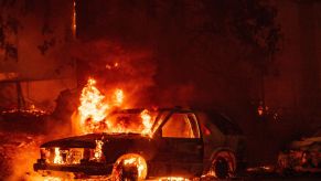 A car on fire in the Indian Falls neighborhood of Plumas County, California during the spread of the Dixie fire