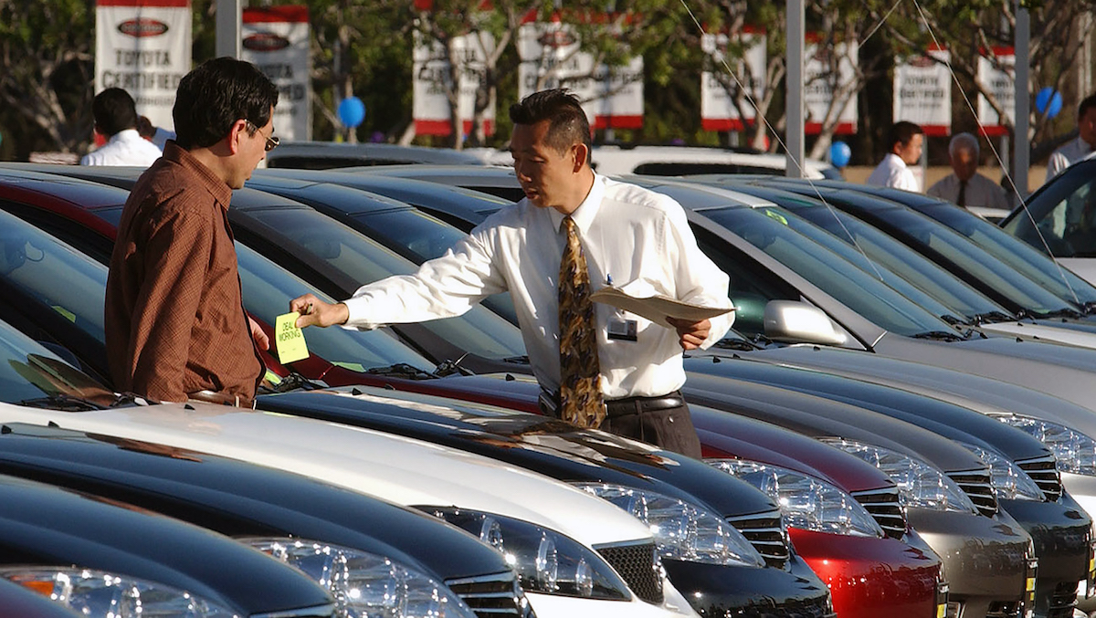 Car salesperson Victor Zeng (right) assists customer Gary Zhao at a Toyota dealership in El Monte, California